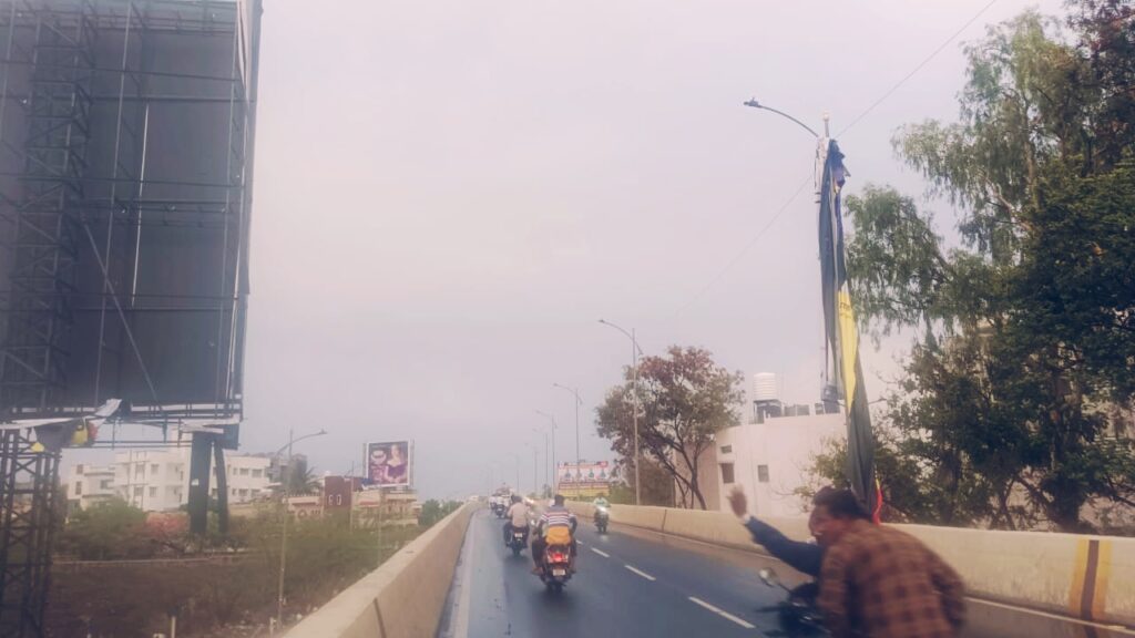 बारामतील उड्डाण पुलाशेजारी लागलेल्या होर्डिगचा प्लेक्स फाटून रस्त्याच्या दुसऱ्या बाजूला उडाला आणि लाईटच्या खांबावर गेला आहे ही घटना होत असताना यात दोघे जन बचावले