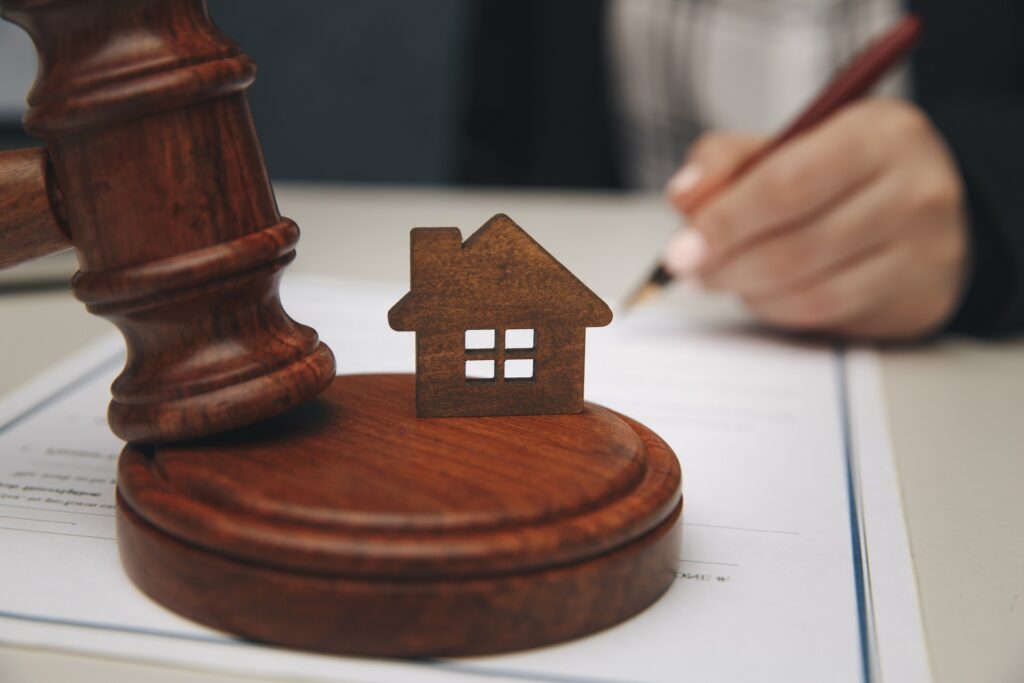 Real Estate Law concept. Model of house and a gavel.